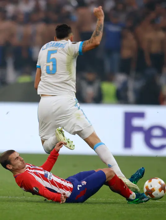 Antoine Griezmann melakukan tackle terhadap pemain Marseille Lucas Ocampos saat pertandingan final Liga Europa di Stade de Lyon, Prancis (16/5). Gol pertama Atletico tercipta pada menit ke-21 melalui aksi Antoine Griezmann. (AP Photo / Francois Mori)