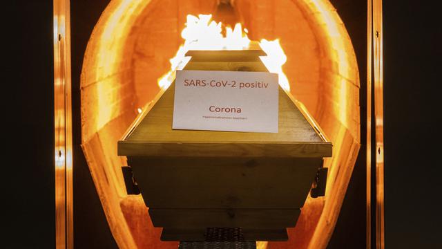 Sebuah peti mati berlabel kertas 'SARS-CoV-2 positif - Corona' dikremasi di krematorium di Giesen, Jerman, 25 November 2021. Badan pengendalian penyakit Jerman mengatakan pihaknya mencatat 351 kematian tambahan akibat COVID-19 dalam 24 jam terakhir. (Julian Stratenschulte/dpa via AP)