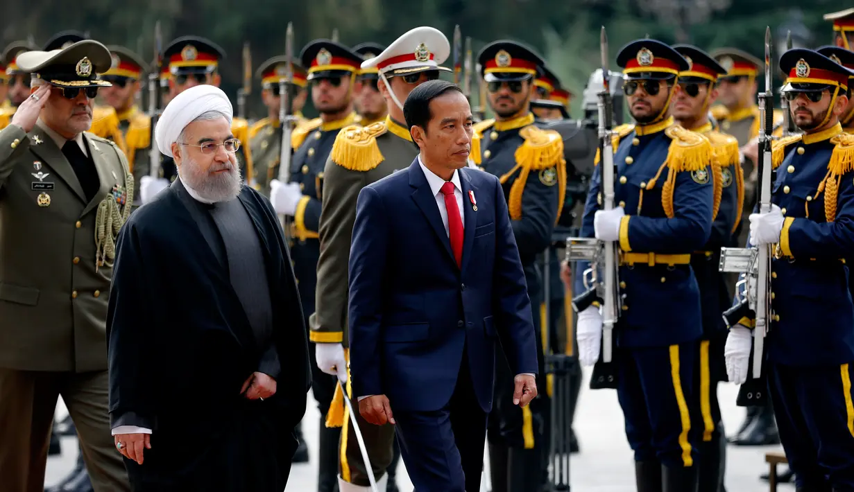 Presiden Joko Widodo bersama Presiden Hassan Rouhani saat mengikuti upacara penghormatan di Istana Saadabad, Rabu (14/12). Pemerintah Indonesia dan Iran sepakat meningkatkan kerja sama di bidang energi dan migas. (AFP Photo/Atta Kenare)