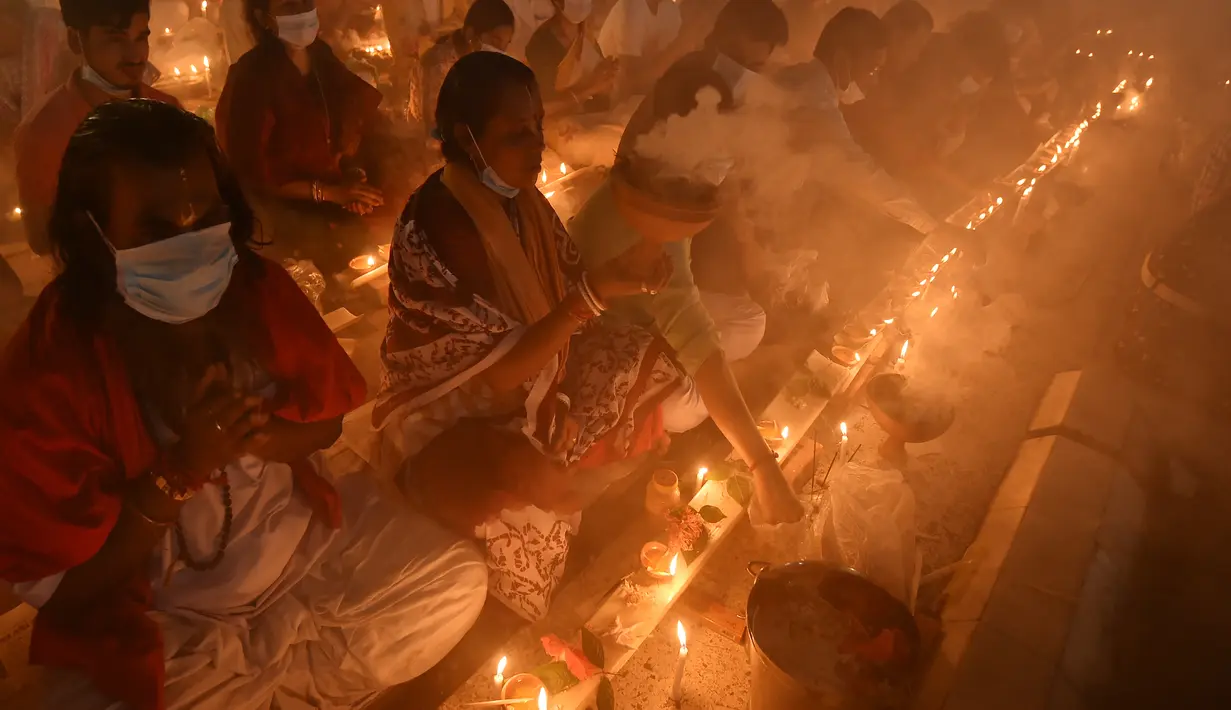 Umat Hindu duduk berdoa sambil membakar dupa dan lampu minyak selama festival puasa keagamaan Rakher Upobash di sebuah kuil di Distrik Narayanganj, pinggiran Dhaka, ibu kota Bangladesh, pada 7 November 2020. (Xinhua)