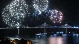 Kembang api menghiasi langit di lokasi pembangunan Jembatan Peljesac di Komarna, Kroasia, Kamis (29/7/2021).  Jembatan itu dirancang untuk menghubungkan dua petak garis pantai Laut Adriatik dan melewati bentangan kecil wilayah Bosnia. (AP Photo)