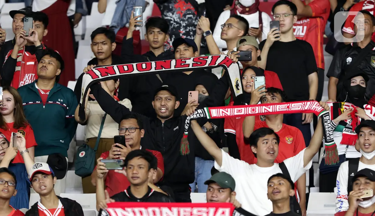 Pendukung timnas Indonesia membentang syal saat menyaksikan laga kualifikasi Grup A Piala AFF 2022 antara Indonesia melawan Kamboja di di Stadion Utama Gelora Bung Karno, Jakarta, Jumat (23/12/2022). Indonesia unggul 2-1 atas Kamboja lewat gol yang dicetak Egy Maulana Vikry dan Witan Sulaeman. (Liputan6.com/Helmi Fithriansyah)
