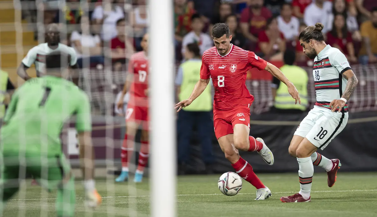 Pemain Swiss Remo Freuler (kiri) berebut bola dengan pemain Portugal Ruben Neves (kanan) pada pertandingan sepak bola Grup A2 UEFA Nations League di Stadion Stade de Geneve, Jenewa, Swiss, 12 Juni 2022. Portugal kalah tipis 0-1 dari Swiss. (Cyril Zingaro/Keystone via AP)