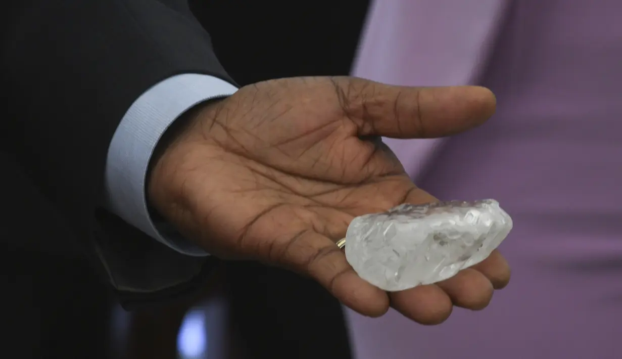 Presiden Botswana Mokgweetsi Masisi memegang berlian permata di Gaborone, ibu kota Botswana, Rabu (16/6/2021). Batu berlian yang diprediksi sebagai yang terbesar ketiga yang pernah ditemukan di dunia kini ditampilkan kepada publik di Botswana, sebuah negara di selatan Afrika. (Monirul Bhuiyan/AFP)