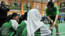Legenda Bulutangkis Indonesia, Susi Susanti memberi tahu cara memegang raket yang benar kepada peserta MILO School Competition 2015, Jakarta, Sabtu (28/11/2015). (Liputan6.com/Yoppy Renato)
