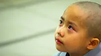 Seorang anak terlihat menangis usai rambutnya dicukur saat upacara pemberkatan Biksu di kuil Jogye, Seoul, Senin (11/5/2015). Upacara ini diadakan bertepatan dengan hari ulang tahun Buddha. (REUTERS/Thomas Peter)