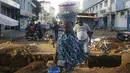 Seorang perempuan menjual makanan di sebuah jalan di Conakry, Guinea, Rabu (8/9/2021). Para pemimpin militer baru Guinea berusaha mempererat cengkeraman mereka pada kekuasaan setelah menggulingkan Presiden Alpha Conde. (AP Photo/Minggu Alamba)