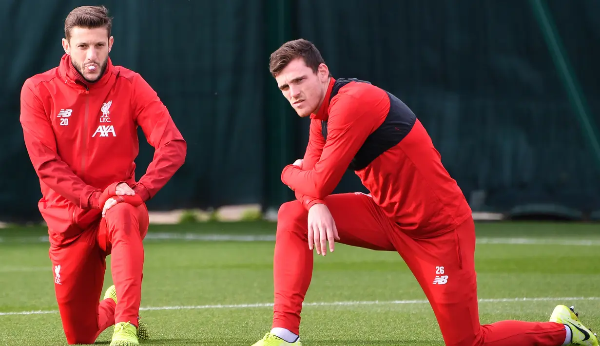 Gelandang Liverpool, Adam Lallana (kiri) dan bek Andrew Robertson melakukan pemanasan selama mengikuti sesi latihan tim di Melwood di Liverpool, Inggris barat laut (22/10/2019). Liverpool akan bertanding melawan wakil Belgia, Genk pada Grup E Liga Champions di Luminus Arena. (AFP/Paul Ellis)