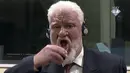 Gambar dari video menunjukkan mantan Jenderal perang Kroasia Bosnia, Slobodan Praljak meminum racun pada persidangan di Den Haag, Rabu (29/11). Aksi terjadi usai hakim menolak banding jenderal yang dituduh sebagai penjahat perang Bosnia itu  (ICTY via AP)