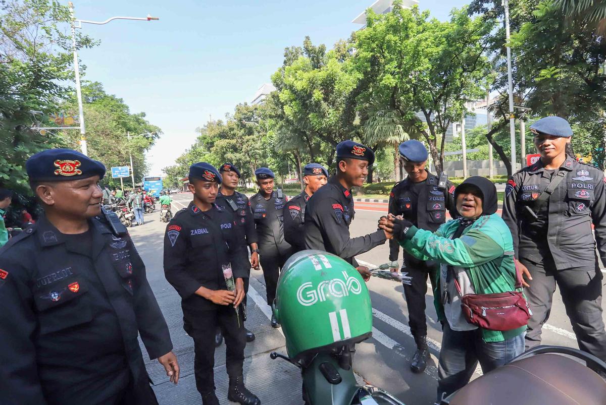 FOTO: Aksi Damai Ojol Tebar Mawar untuk Perdamaian