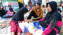 Tradisi makan bersama sambil menggelar tiker di tempat wisata menjadi pilihan sebagian besar warga yang mengunjungi tempat wisata Taman Mini Indonesia Indah, Jakarta, Minggu (19/07/2015). (Liputan6.com/Yoppy Renato)
