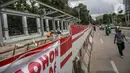 Warga berjalan melintasi proyek pembangunan selter di kawasan Stasiun Palmerah, Jakarta, Selasa (2/2/2021). Penataan ini diharapkan bisa menjadi solusi kemacetan yang kerap terjadi di kawasan tersebut. (Liputan6.com/Faizal Fanani)