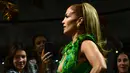 Bintang pop dan aktris, Jennifer Lopez mengenakan gaun Versace untuk Spring/Summer Collection 2020 pada Milan Fashion Week 2019, Jumat (20/9/2019). Jennifer Lopez mengenakan versi baru gaun hijau ikonis yang pernah ia gunakan di Grammy Awards 20 tahun lalu. (Miguel MEDINA/AFP)