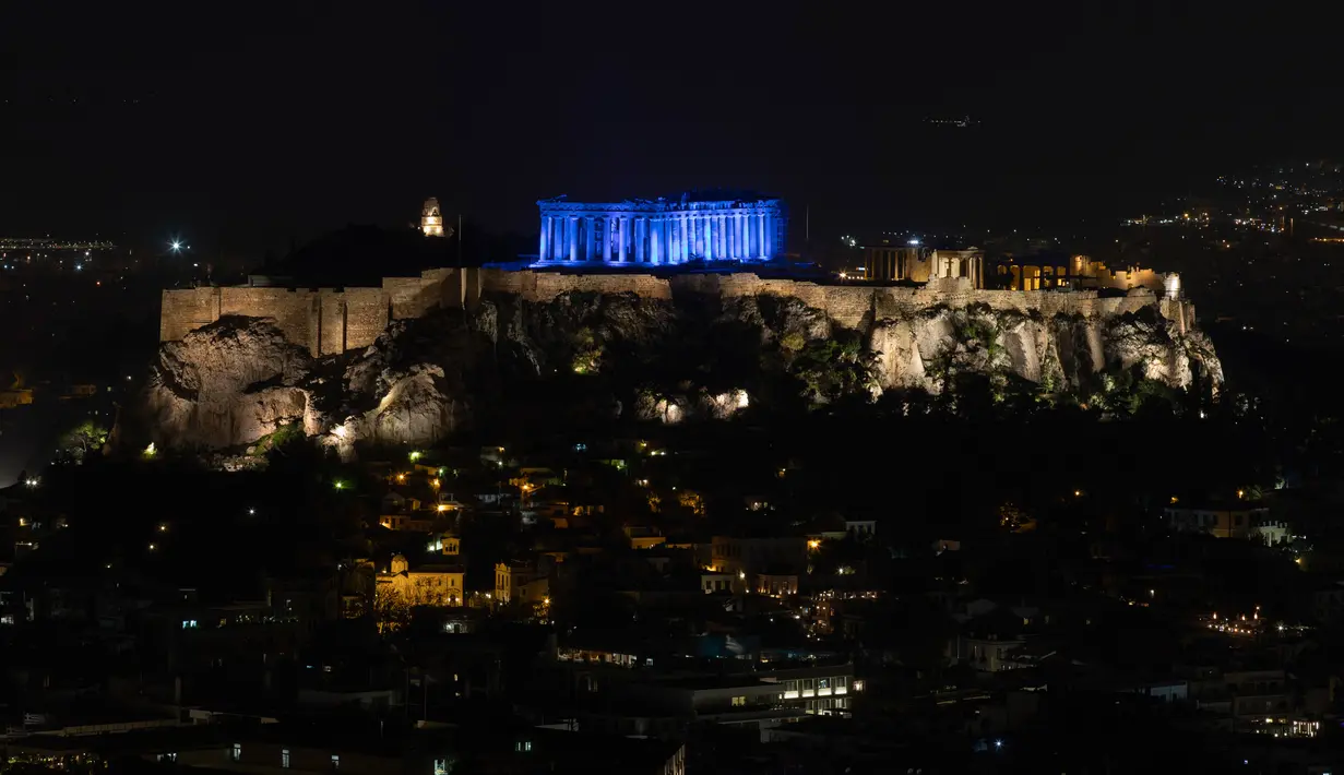 Situs warisan dunia Kuil Parthenon berwarna biru saat Hari Anak Sedunia, Athena, Yunani, Rabu (20/11/2019). Nuansa biru pada kuil yang berada di puncak bukit Acropolis tersebut untuk memperingati Hari Anak Sedunia yang jatuh setiap tanggal 20 November. (AP Photo/Petros Giannakouris)