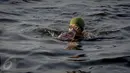 Supardi berenang untuk mencari kerang hijau di dekat kapal Tongkang di kawasan pesisir Cilincing, Jakarta, Jumat (17/6). (Liputan6.com/Faizal Fanani)