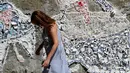 Seorang wanita melewati mural yang menggambarkan 'Meninas' selama festival seni jalanan tahunan Meninas de Canido di Ferrol, Spanyol, Minggu (2/9). Festival Meninas de Canido berawal dari aksi protes masyarakat. (MIGUEL RIOPA/AFP)