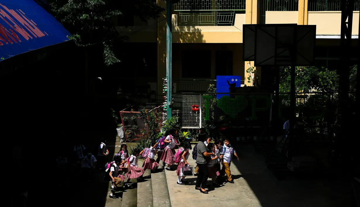 Siswa mengantre di sekolah umum di Kota Quezon, Filipina pada Rabu (2/11/2022). Jutaan siswa kembali ke sekolah umum di seluruh Filipina saat pemerintah memberlakukan kembali pembelajaran di kelas secara tatap muka setelah lebih dari dua tahun lockdown akibat pandemi virus corona. (AP Photo/Aaron Favila)