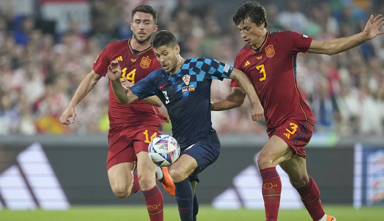 Striker Timnas Kroasia, Andrej Kramaric (tengah) menguasai bola dibayangi dua pemain Timnas Spanyol, Aymeric Laporte (kiri) dan Robin Le Normand pada laga final UEFA Nations League 2022/2023 di De Kuip Stadium, Rotterdam, Senin (19/6/2023) dini hari WIB. (AP Photo/Martin Meissner)