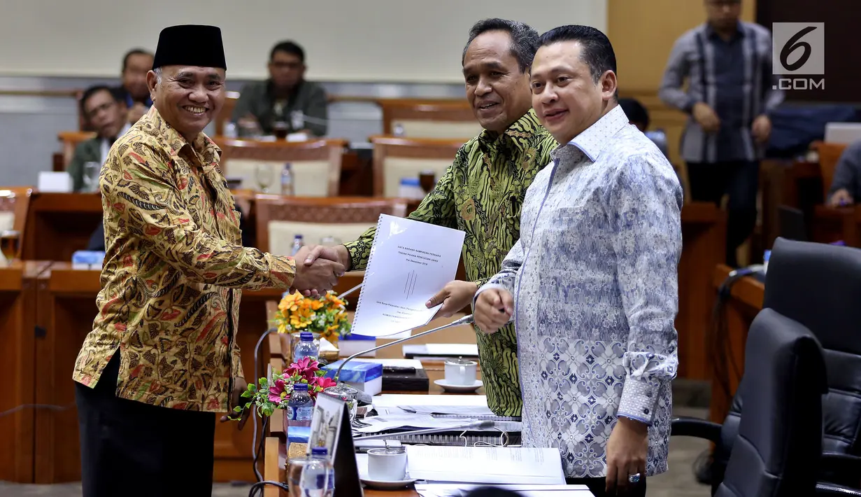 Ketua KPK Agus Rahardjo menyerahkan daftar barang sitaan kepada pimpinan rapat dengar pendapat (RDP) Komisi III, Benny K. Harman di gedung DPR, Senayan, Jakarta, Selasa (26/9). Rapat tersebut membahas evaluasi kinerja KPK. (Liputan6.com/Johan Tallo)