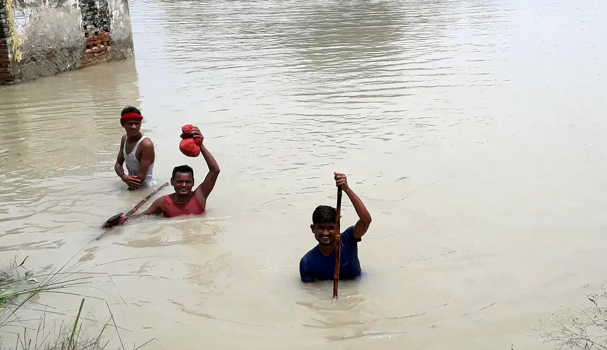 Penduduk desa menerjang banjir di Distrik Muzaffarpur, Negara Bagian Bihar, India timur, pada 26 Juli 2020. Sedikitnya 10 orang tewas dan hampir 1,5 juta orang terkena dampak akibat banjir di 11 distrik di Bihar, papar Departemen Manajemen Bencana Bihar dalam sebuah buletin. (Xinhua/Partha Sarkar)
