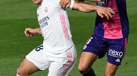 Bek Valladolid Javi Sanchez (tengah) menantang penyerang Real Madrid, Luka Jovic pada lanjutan La Liga Spanyol di stadion Alfredo, Rau (30/9/2020). Real Madrid menekuk Real Valladolid denga skor 1-0. (PIERRE-PHILIPPE MARCOU / AFP)