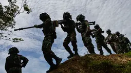 Sejumlah prajurit TNI dari batalyon infantri Raider 112 berjalan membawa senjata berat untuk latihan menembak di Mata Ie, Aceh Besar, Aceh, Selasa (11/6/2019). Latihan ini untuk menjaga keutuhan negara dari ancaman serta gangguan baik dari dalam maupun luar negeri. (AFP Photo/Chaideer Mahyuddin)