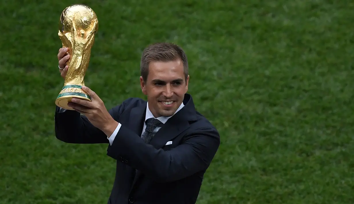 Mantan kapten Jerman Philipp Lahm mempersembahkan trofi Piala Dunia pada penutupan Piala Dunia 2018 Rusia sebelum pertandingan sepak bola final antara Prancis dan Kroasia di Stadion Luzhniki, Moskow (15/7). (AFP Photo / Gabriel Bouys)