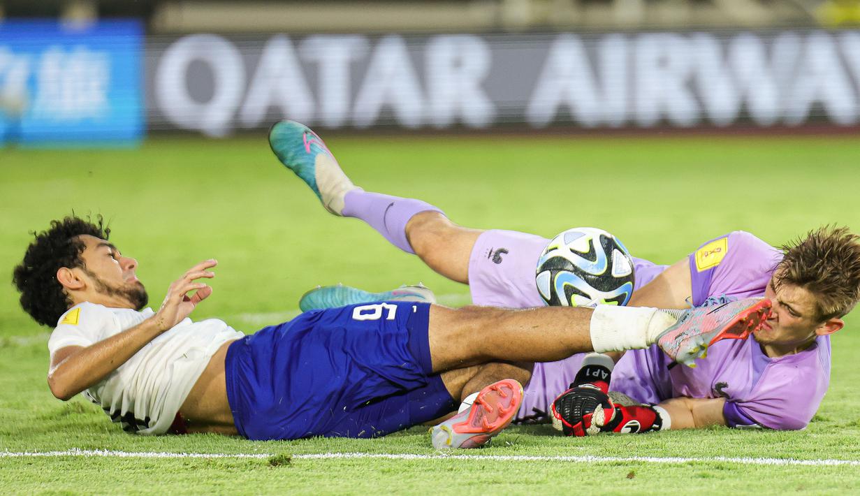 Kiper Timnas Prancis U-17, Paul Argney (kanan) berusaha menangkap bola dari ancaman pemain Timnas Uzbekistan U-17, Amirbek Saidov pada laga perempat final Piala Dunia U-17 2023 di Stadion Manahan, Solo, Sabtu (25/11/2023). (Doc. LOC WCU17/NFL)
