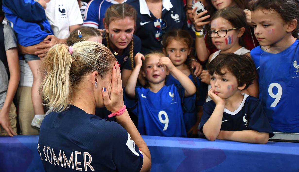 Eugenie Le Sommer striker Prancis tak kuasa menyembunyikan rasa kecewanya bersama suporter cilik setelah Prancis gugur di permepat final Piala Dunia Wanita 2019.  ( AFP/Franck Fife )