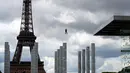 Pengunjung meluncur dengan seutas tali saat melakukan permainan Zip Line dari lantai dua Menara Eiffel di atas taman Champ de Mars, Paris, Selasa (28/5/2019). Permainan ini akan membiarkan pengunjung terbang di atas kerumunan turis di Champs de Mars sebelum mendarat dengan selamat (AP/Francois Mori)