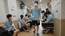 Sejumlah pemuda Korea Selatan menekan lengan mereka setelah melakukan tes darah saat pemeriksaan medis untuk wajib militer di Administrasi Tenaga Kerja Militer Regional Seoul, Seoul, Korea Selatan, Rabu (1/2/2023). Beberapa minggu awal mengikuti wajib militer, mereka diberikan pelatihan dasar militer meliputi latihan fisik seperti push up, marching, sampai latihan menembak. (Jung Yeon-je/AFP)