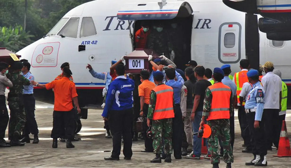 Empat peti jenazah korban kecelakaan Trigana Air diturunkan dari pesawat di Bandara Sentani, Kabupaten Jayapura, Papua, Rabu (19/8). Lima awak dan 49 penumpang menjadi korban kecelakaan pesawat pada 16 Agustus 2015 lalu. (AFP PHOTO/Indrayadi Thamrin)