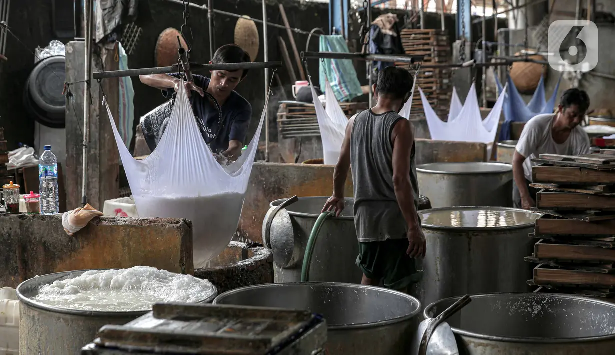 Pekerja menyaring sari kedelai saat membuat tempe di kawasan Duren Tiga Raya, Jakarta, Kamis (24/2/2022). Produsen tahu tempe kembali berproduksi usai mogok selama tiga hari karena harga kedelai yang naik hingga menyentuh Rp12.000 per kg dalam beberapa bulan terakhir. (Liputan6.com/Faizal Fanani)