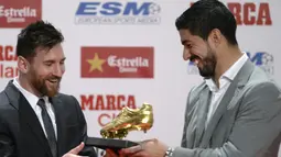 Lionel Messi (kiri) menerima penghargaan sepatu emas Eruopa dari rekannya Luis Suarez pada acara Golden Shoe awards 2017 di Antigua Fabrica Estrella Damm, Barcelona, (24/11/2017). (AFP/Josep Lago)
