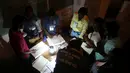 Para petugas menghitung jumlah suara di sebuah Tempat Pengumutan Suara (TPS) di Port-au-Prince, Haiti (20/11). Akibat badai Matthew yang sebelumnya melanda kota ini, pemilu harus digelar dengan penerangan seadanya. (Reuters/Jeanty Junior Augustin)