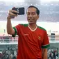 Presiden Jokowi membuat vlog saat menyaksikan laga final Piala Presiden 2018 antara Persija Jakarta vs Bali United di Stadion Utama Gelora Bung Karno, Sabtu (17/2). Jokowi terlihat menggunakan busana kasual. (Liputan6.com/Pool/Biro Pers Setpres)