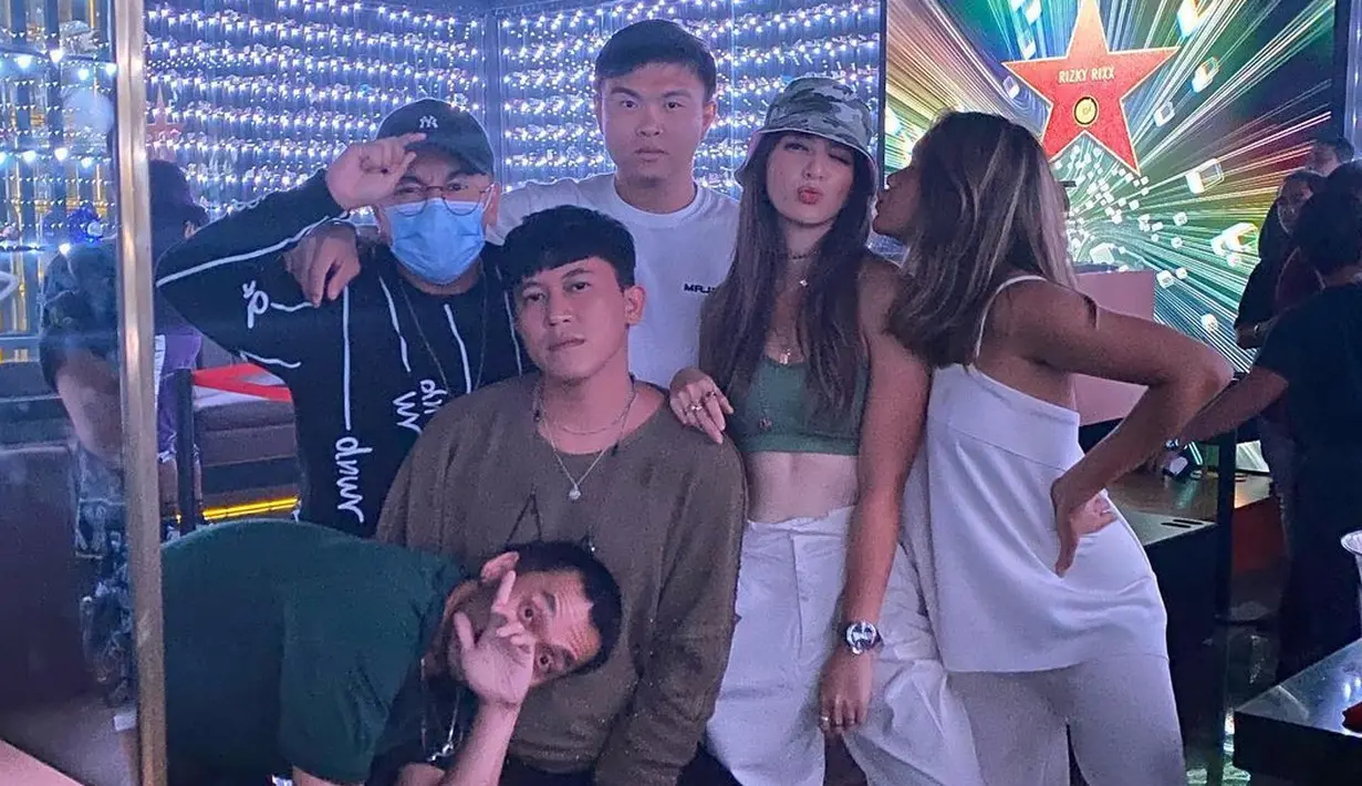 Nia Ramadhani tampil mengenakan bucket hat bermotif army yang dipadukannya dengan tampilan serupa. Crop top bernuansa hijau dan celana panjang putih. Foto: Instagram.