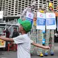 Tiga seniman egrang membawa poster Kampanye Aman Untuk Anak pada acara Deklarasi Pemilu Ramah Anak di Gedung Bawaslu, Jakarta, Minggu (17/3). KPU melarang anak-anak untuk terlibat dalam aktivitas kampanye politik. (Liputan6.com/Herman Zakharia)