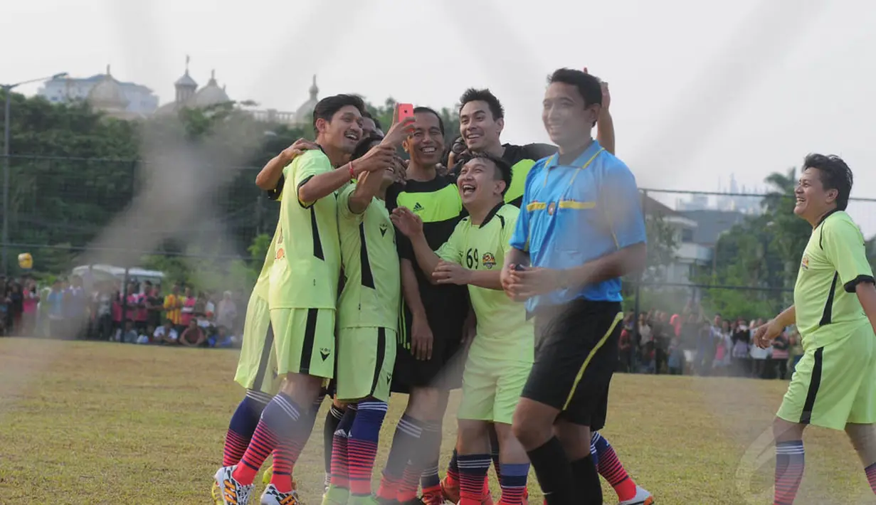 Usai menciptakan gol, Jokowi langsung berfoto selfie dengan para pemain lainnya, Jakarta, Minggu (17/8/14). (Liputan6.com/Herman Zakharia)