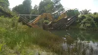 Kendaraan alat berat yang membuat jembatan penghubung di Desa Sungai Rambutan Ogan Ilir Sumsel ambruk (Liputan6.com / Nefri Inge)