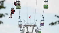 Tim pemadam kebakaran mengevakuasi penumpang kereta gantung yang terjebak di udara di Kota Koln, Jerman, Minggu (30/7). Setidaknya 100 orang terjebak setelah kereta gantung yang ditumpanginya menabrak tiang dan mendadak terhenti (Rainer Jensen/dpa via AP)