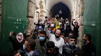 Muslim Palestina masuk untuk beribadah di kompleks masjid al-Aqsa, situs paling suci ketiga bagi Islam, di Yerusalem, Minggu (31/5/2020). Kompleks masjid Al-Aqsa kembali dibuka hari ini, Minggu (31/5) setelah ditutup dua bulan sebagai bagian upaya memutus penularan virus corona (Ahmad GHARABLI/AFP)