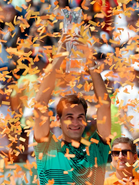 Petenis Swiss, Roger Federer mengangkat tropi usai memenangkan pertandingan pada final Miami Terbuka di Crandon Park, Florida (2/4). Federer menundukkan rival lamanya, Rafael Nadal dua set langsung 6-3, 6-4. (AP Photo/Wilfredo Lee)