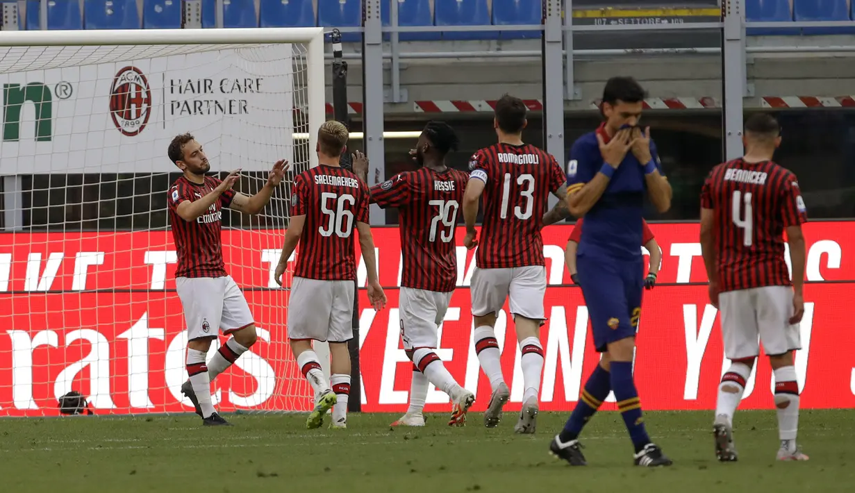 Pemain AC Milan Hakan Calhanoglu (kiri) merayakan golnya ke gawang AS Roma bersama rekan-rekannya pada pertandingan Serie A di Stadion San Siro, Milan, Minggu (28/6/2020). AC Milan naik ke posisi 7 klasemen dengan 42 poin usai mengalahkan AS Roma 2-0. (AP Photo/Luca Bruno)