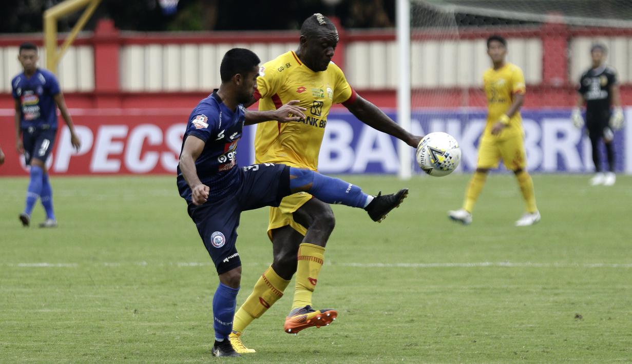 Striker Bhayangkara FC, Herman Dzumafo, berebut bola dengan pemain Arema FC pada laga Shopee Liga 1 di Stadion PTIK, Jakarta, Rabu (27/11). Bhayangkara menang 1-0 atas Arema. (Bola.com/Yoppy Renato)