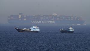 Dua perahu tradisional berlayar melewati sebuah kapal kontainer besar di Selat Hormuz, Jumat, 19 Mei 2023. (AP/Jon Gambrell)