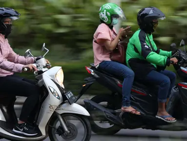 Pengemudi ojek online melintasi Jalan Pintu I Senayan, Jakarta, Selasa (19/3). Kemenhub mengeluarkan Permen No.12 tahun 2019 tentang perlindungan keselamatan pengguna motor yang digunakan untuk kepentingan masyarakat. (Liputan6.com/Helmi Fithriansyah)