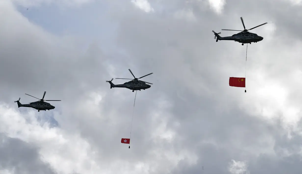Bendera China (kanan) dan Hong Kong (tengah) diterbangkan dengan helikopter saat upacara untuk memperingati 23 tahun penyerahan Hong Kong dari Inggris ke China di Hong Kong, Rabu (1/7/2020). Hong Kong menandai 23 tahun penyerahan dari Inggris ke Cina pada 1 Juli. (Anthony WALLACE/AFP)