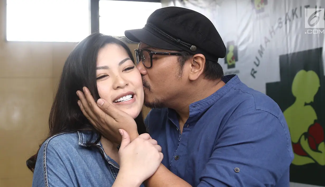 Sammy Simorangkir mencium sang istri, Viviane saat jumpa pers kelahiran anak pertama mereka di rumah sakit kawasan Jatinegara, Jakarta, Jumat (24/8). Sammy dan Viviane memberi nama anak mereka Gevariel Jogi Simorangkir. (Liputan6.com/Herman Zakharia)