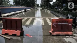 Pembatas jalan dipasang untuk menghalau kendaraan melintasi lokasi banjir di Jalan RE Martadinata, Ancol, Jakarta, Selasa (9/11/2021). Banjir mengakibatkan akses dari arah Jalan Gunung Sahari menuju Penjaringan ditutup sementara dan dialihkan. (merdeka.com/Iqbal S. Nugroho)